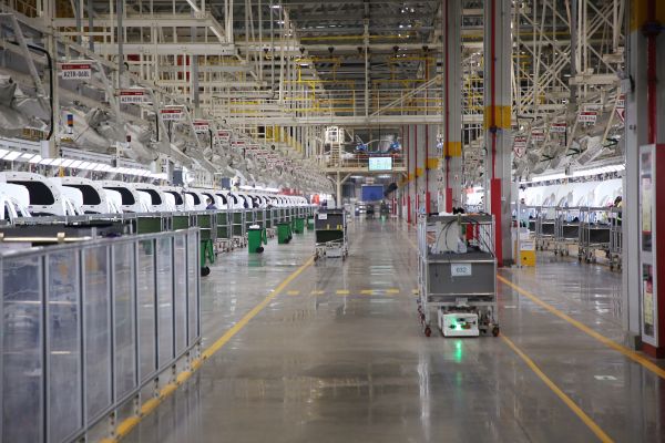 自動化牽引小車穿行在北汽株洲基地二工廠的總裝車間里。