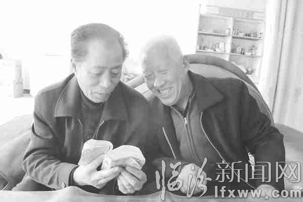 許甲才(左)正在給村民講日歷冊中的古代傳說