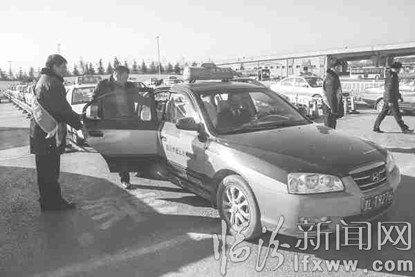 高鐵站服務隊隊員正在引導乘客乘坐出租車