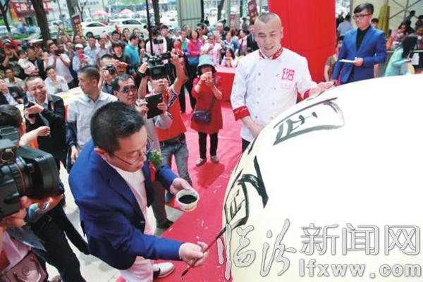 岳更生(前左)在面氣球上寫下“中國剪刀面”。