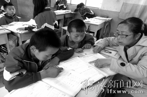 趙燁在輔導學生寫作業。